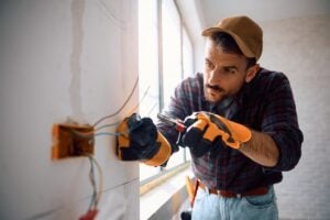 Cable para instalación eléctrica en casa - Electricista profesional que trabaja con cable.